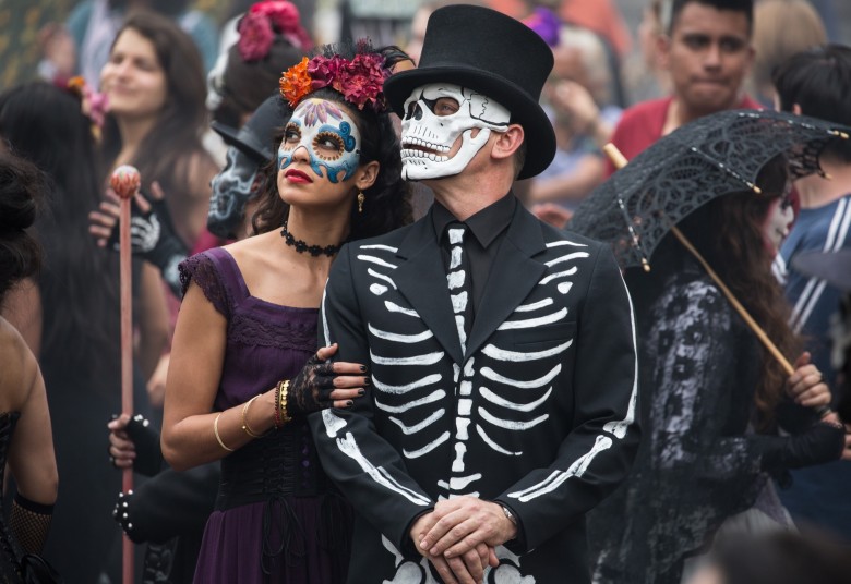 474945 - "Spectre" - B24_16958 - Estrella (Stephanie Sigman) and Bond (Daniel Craig) in the crowds of El Dia de los Muertos procession in Metro-Goldwyn-Mayer Pictures/Columbia Pictures/EON Productions’ action adventure SPECTRE. Tolsa Square, Mexico City.